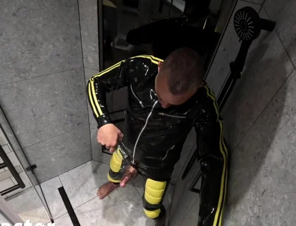 Rubber Man Pisses with Uncut Cock