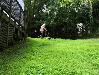Big Fake Tits Crossdresser in Daisy Dukes Mowing Grass